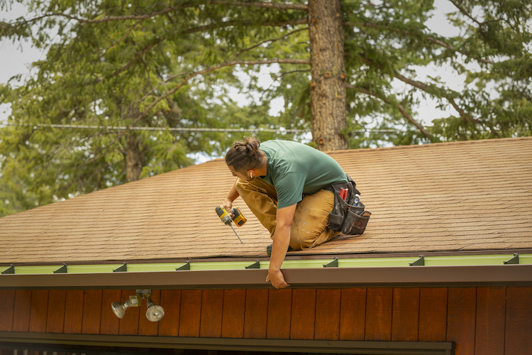 Man on House Roof Installing Gutters - K-Guard Heartland
