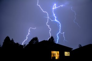 Large Lightning Bolts in Dark Sky Behind Home - K-Guard Heartland